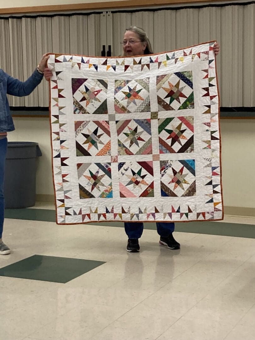 People holding a quilt