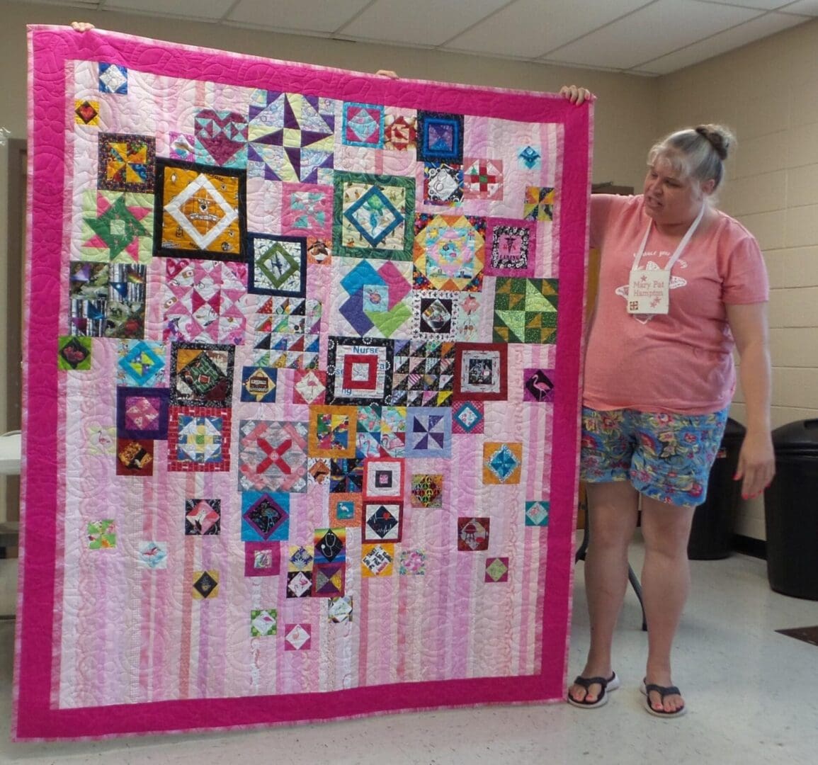 a woman looking at a pink mat with quilt work